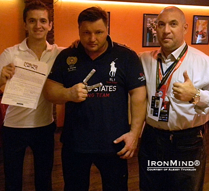 Alexey Tyukalov (center), just certified on the Captains of Crush (CoC) No. 3 gripper, is flanked by his referee, Oleg Chernov of AerRus (left), and by the president of the Armlifting Association of Russia, Nikolai Vitkevich (right).  IronMind&reg; | Courtesy of Alexey Tyukalov. 